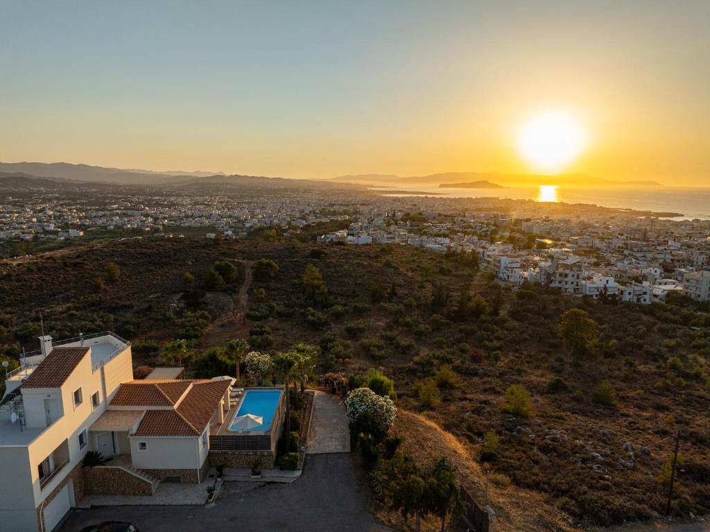 een luchtfoto van een huis met de zonsondergang op de achtergrond bij Karmilos Hill Villa in Chania