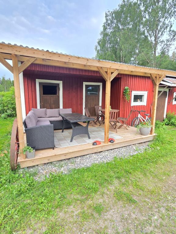 a wooden deck with a couch and a table at Vanha myllärin torppa in Sulkava