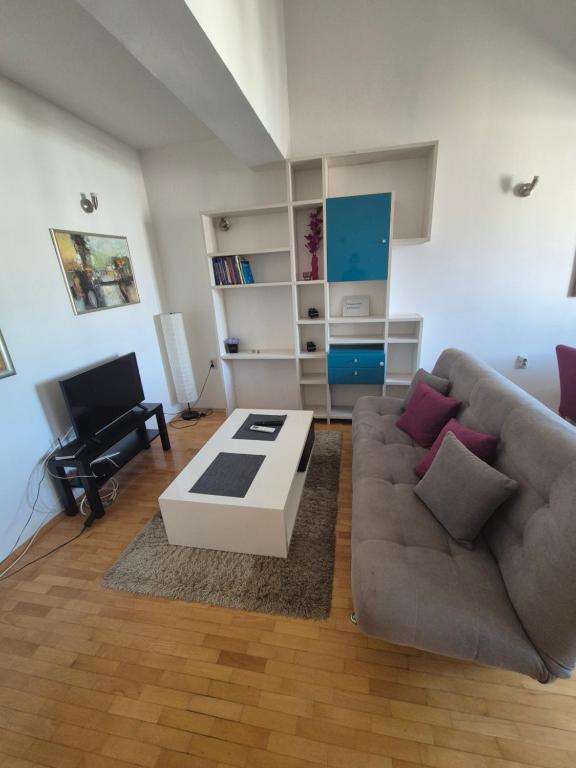 a living room with a couch and a coffee table at VORTEX Apartment Skopje in Skopje