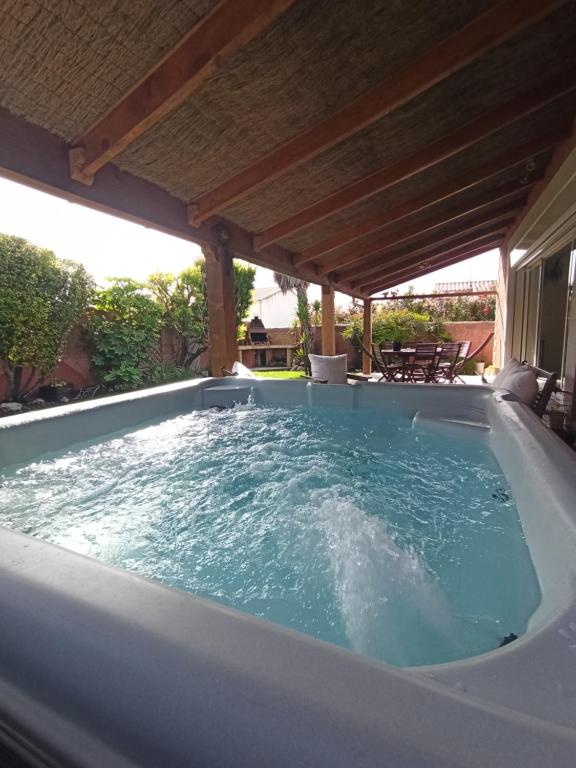 un jacuzzi sous une pergola dans l'établissement Villa au calme 6 à 8 pers avec jacuzzi et salle fitness, à Gigean