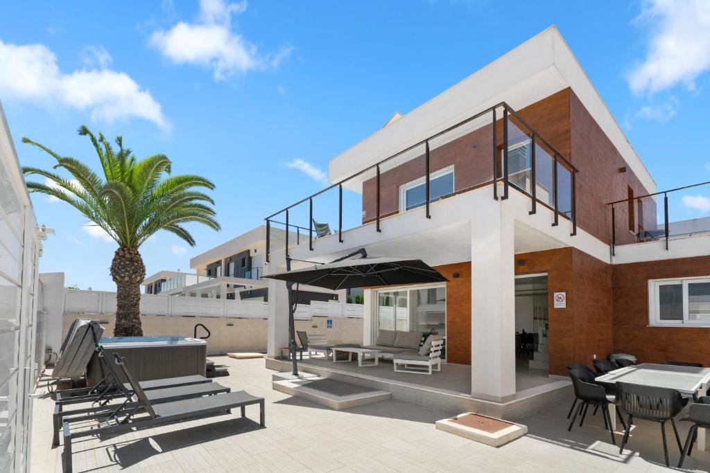 a house with a patio with tables and chairs at Casa Bos Flamingo Pool and Jacuzzi in Puerto Marino