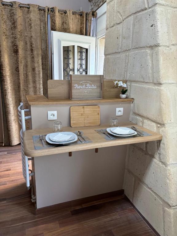 une table avec deux assiettes dessus à côté d'un mur de briques dans l'établissement Mini duplex la Révière, à Saintines