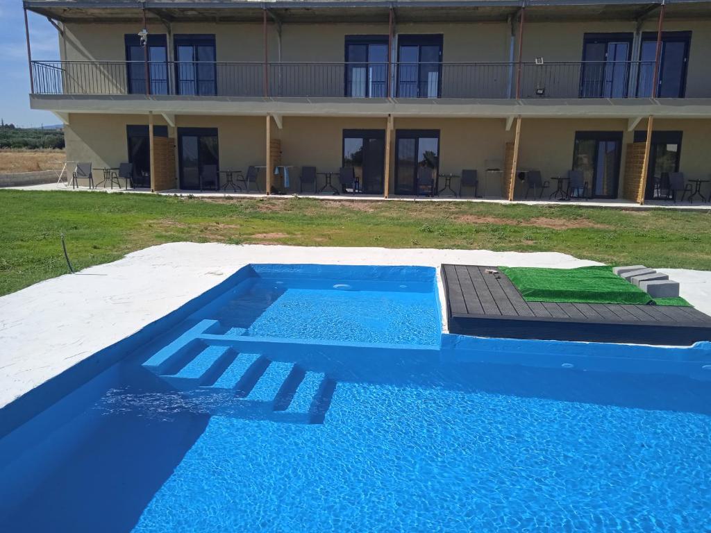 a house with a swimming pool in front of a building at Bella Kaliva in Kalyves Poligirou