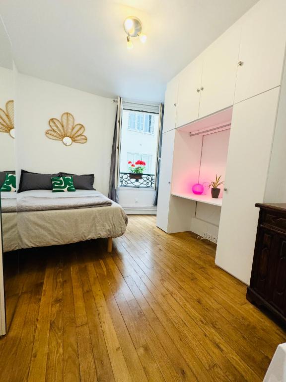 une chambre avec un lit et un parquet dans l'établissement Bel appart proche Tour Eiffel, à Paris