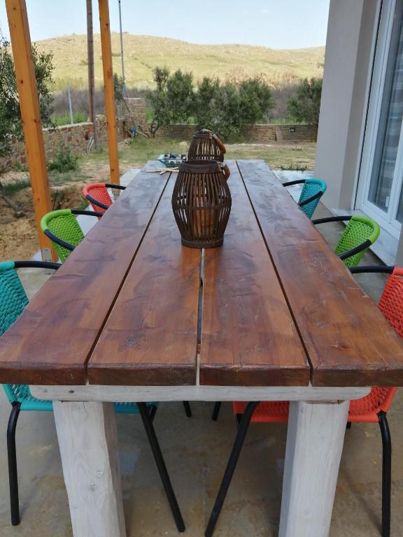 a wooden table with a vase sitting on top at Havouli Cottage in Moúdhros