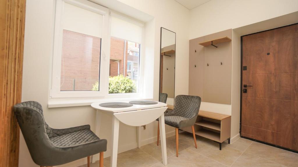 a bathroom with a sink and two chairs and a window at Red House Corner in Marijampolė