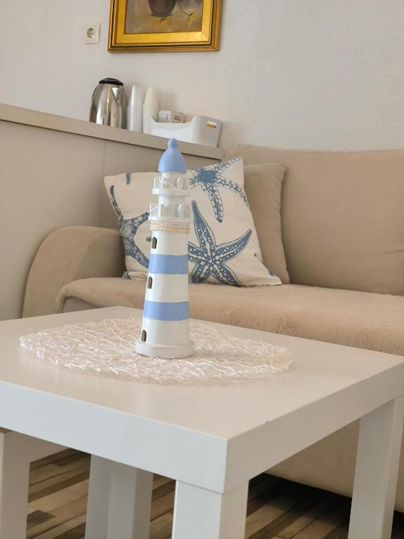 a white coffee table with a lighthouse toy on it at Apartman Zora in Neum