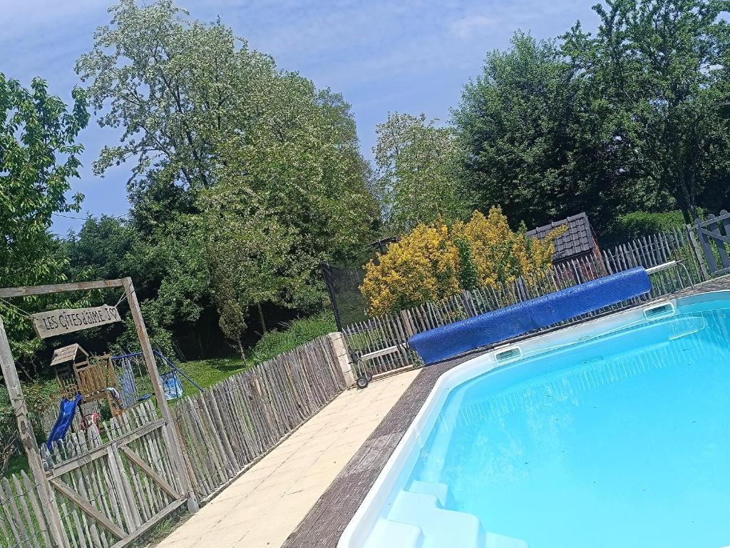 - une piscine à côté d'une clôture en bois dans l'établissement Petit studio avec piscine, à Dussac