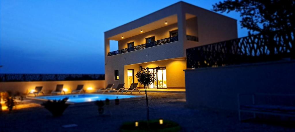 Una casa grande con piscina delante de ella. en Villa Mare Pirovac, en Pirovac