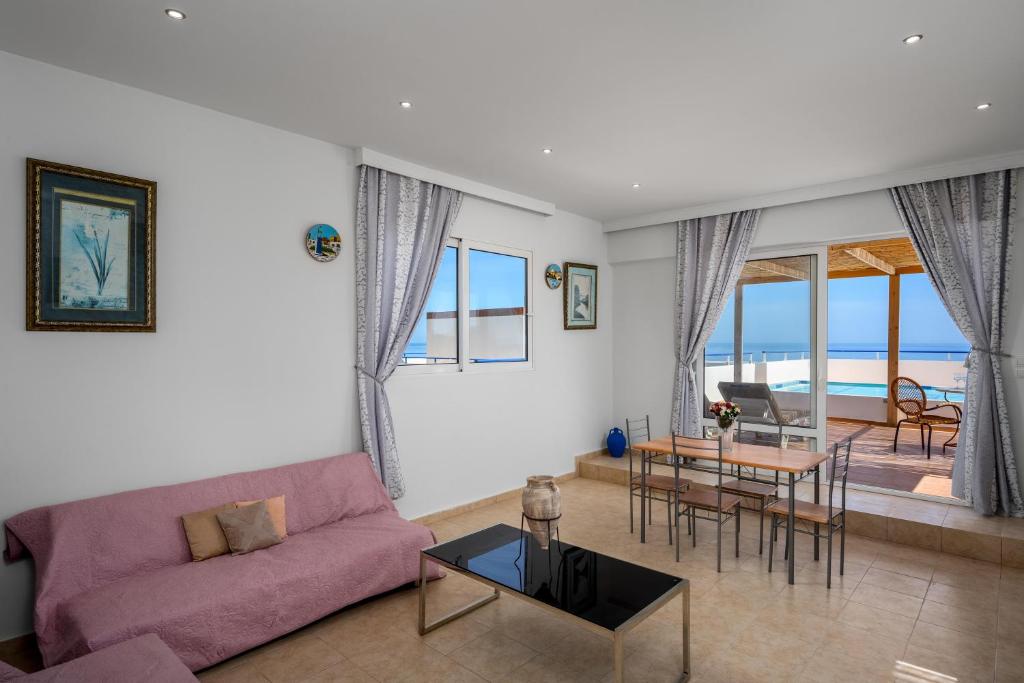 a living room with a purple couch and a table at Exquisite Retreat For Two in Archangelos