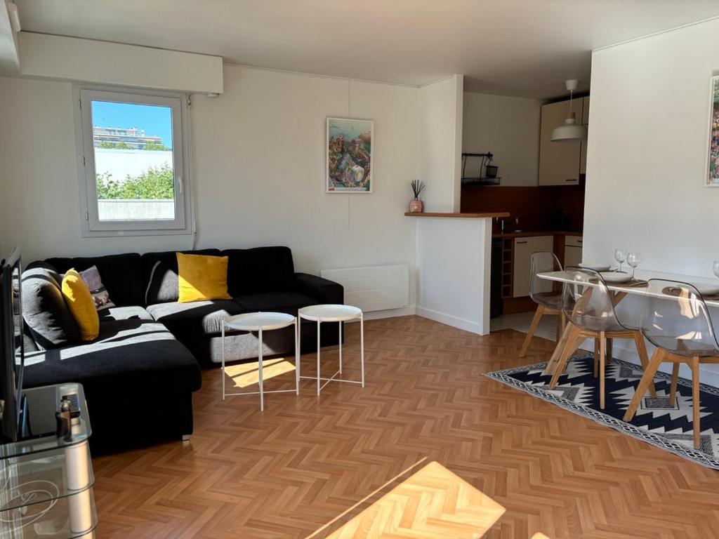 un salon avec un canapé noir et une table dans l'établissement T2 La Rochelle 500m Vieux-Port avec parking, à La Rochelle