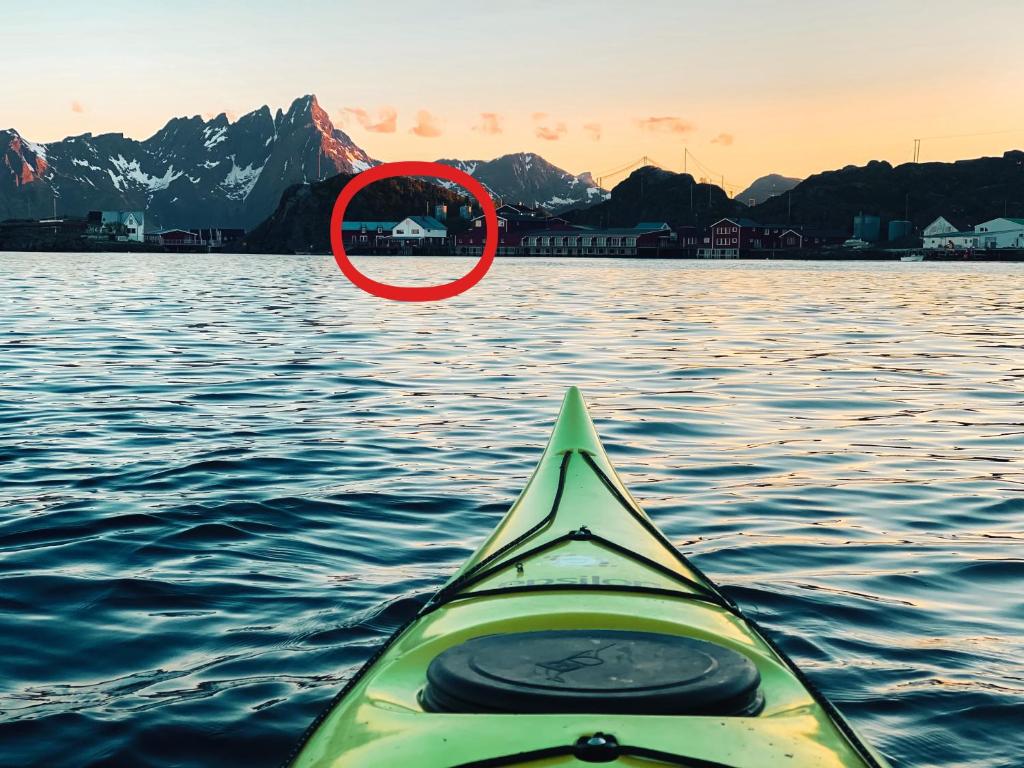 a kayak in the water with a red circle at Gammelbutikken Guesthouse in Pettvik