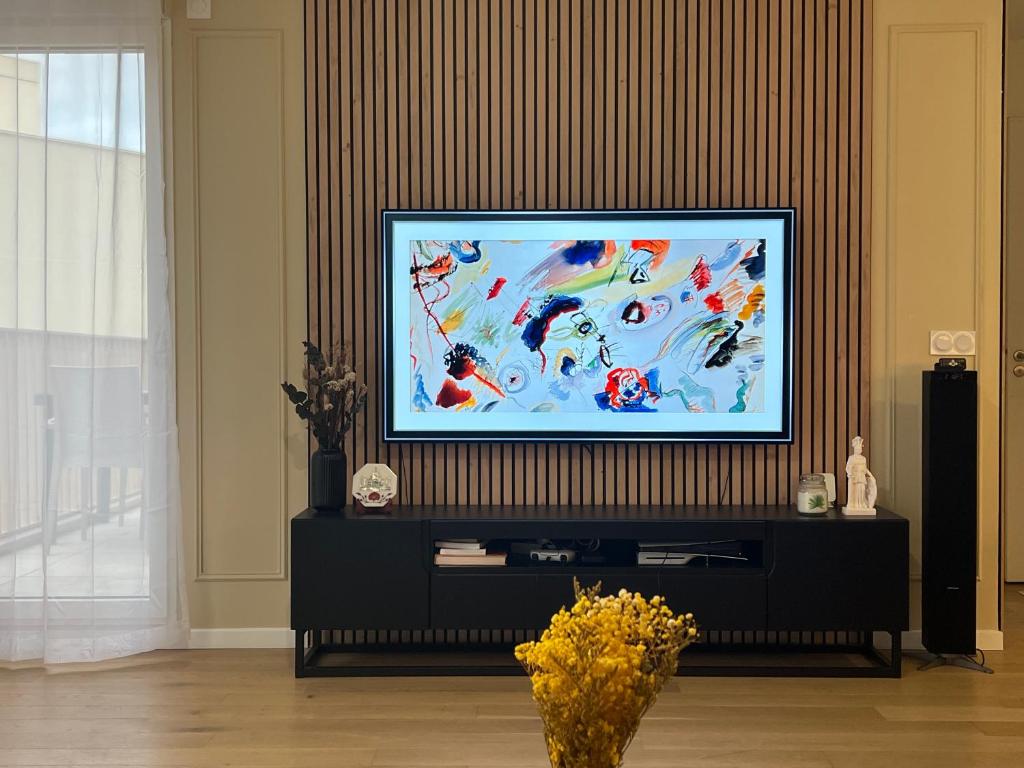 a flat screen tv sitting on top of a black entertainment center at Beautiful 1 bedroom apartment in Paris 17 - Clichy in Clichy