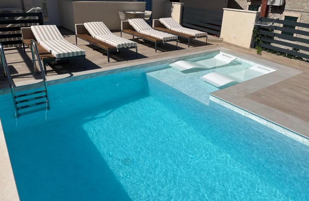 a blue swimming pool with chairs and a table at Apartments Villa De Blue in Bol