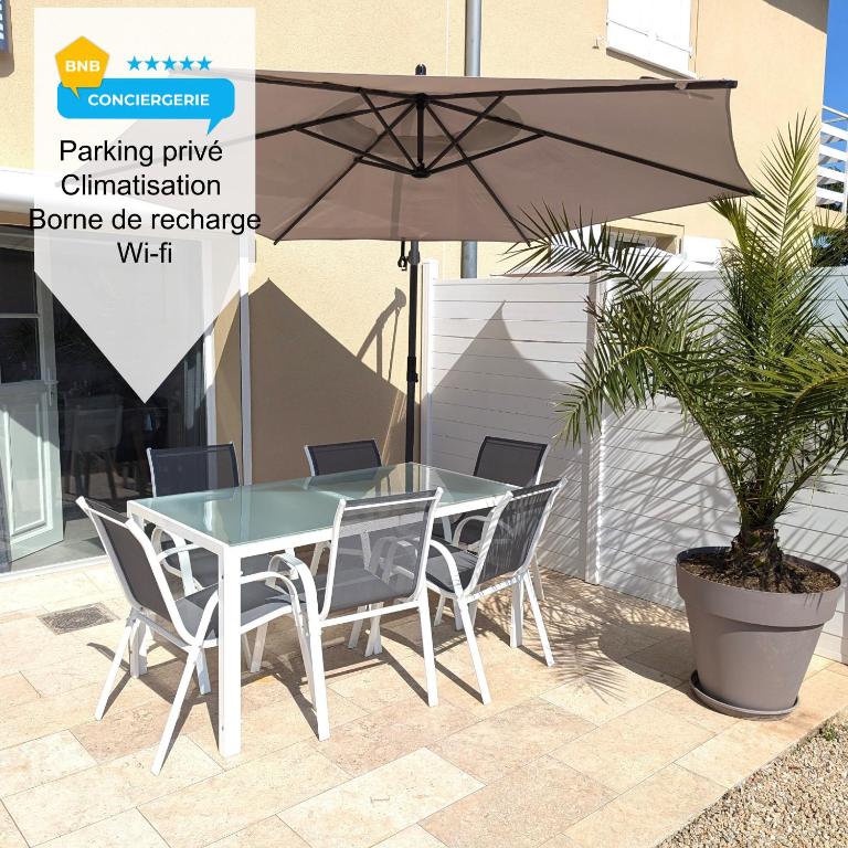 - une table, des chaises et un parasol sur la terrasse dans l'établissement Cosy 152 proche aéroport -gare-groupama stadium-lyon, à Colombier-Saugnieu