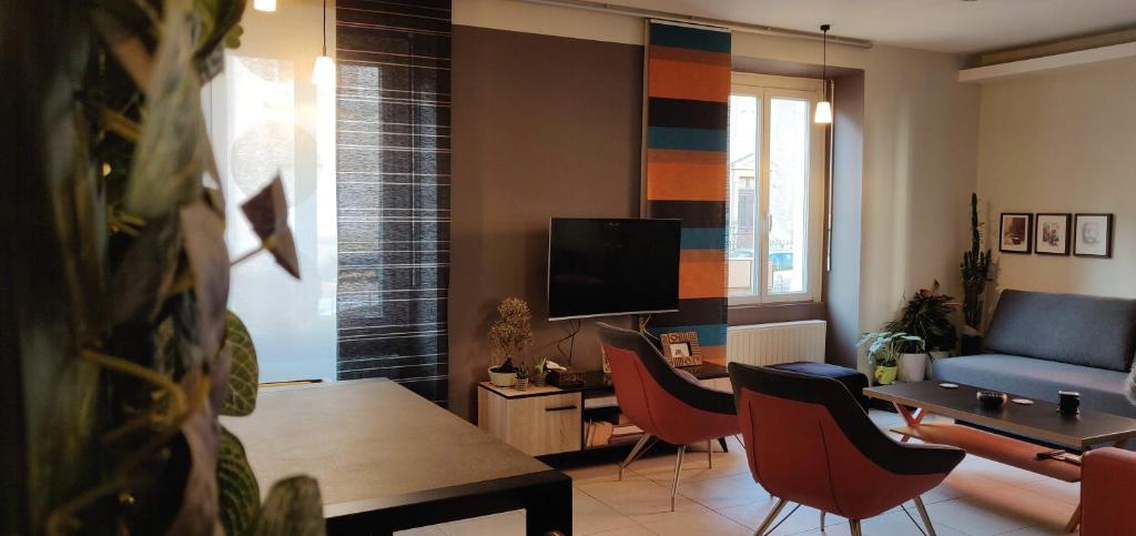 a living room with a couch and a table and chairs at Appartement de charme 1860-1900 in Colmar