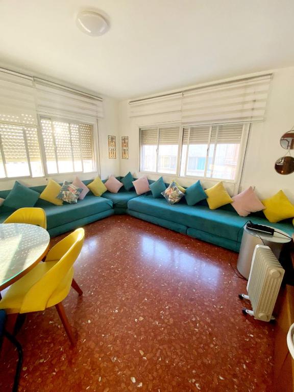 a living room with a blue couch with colorful pillows at Genial casa en centro in Ceuta