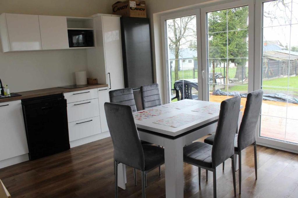 una cucina e una sala da pranzo con tavolo e sedie di Zielony Zakątek a Stary Bubel