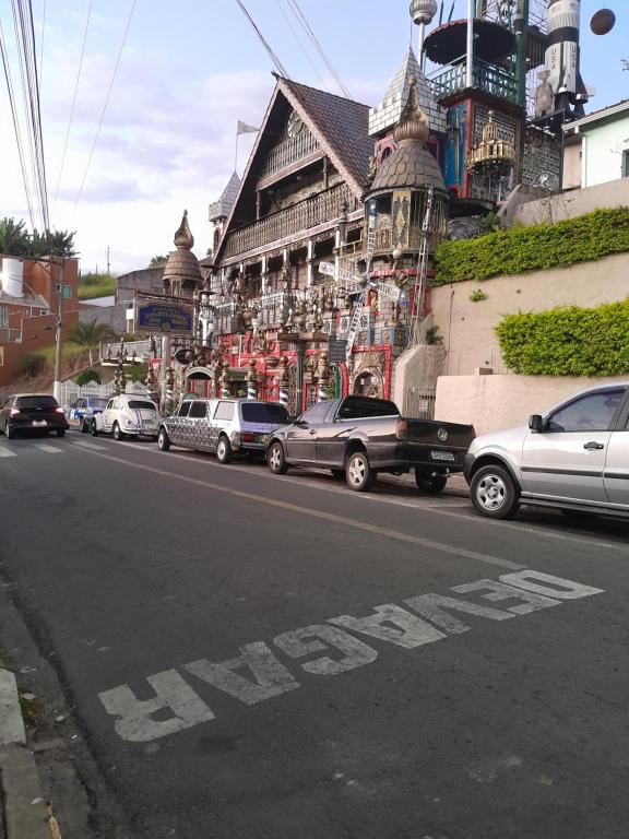 a street with cars parked in front of a building at Casa central in Serra Negra
