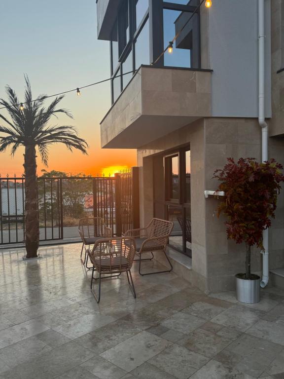 a balcony with a table and chairs and a palm tree at Ivon Apartments in Sozopol