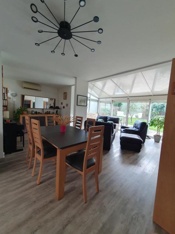 une salle à manger et un salon avec une table et des chaises dans l'établissement Maison de plain pied proche JO 2024, à Élancourt