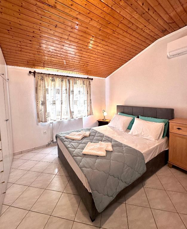 a bedroom with a large bed with a wooden ceiling at Katerinas House 2 in Skriperón