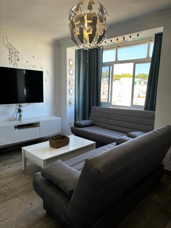 ein Wohnzimmer mit Sofa und Fernseher in der Unterkunft Apartamento Valdés in El Puerto de Santa María