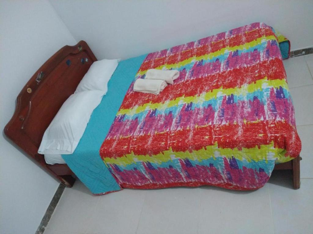 un letto con una coperta colorata sopra di Casa acogedora Girardot 150mts a Girardot
