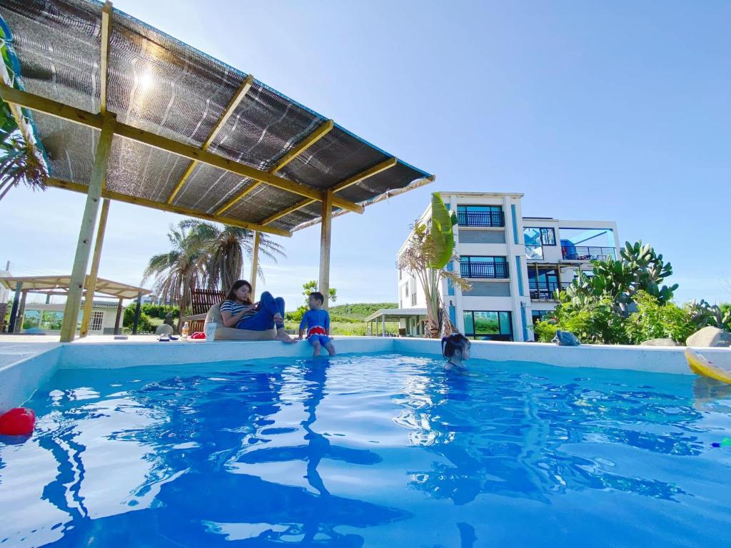 una famiglia in piscina in un resort di Big Fish Homestay a Magong