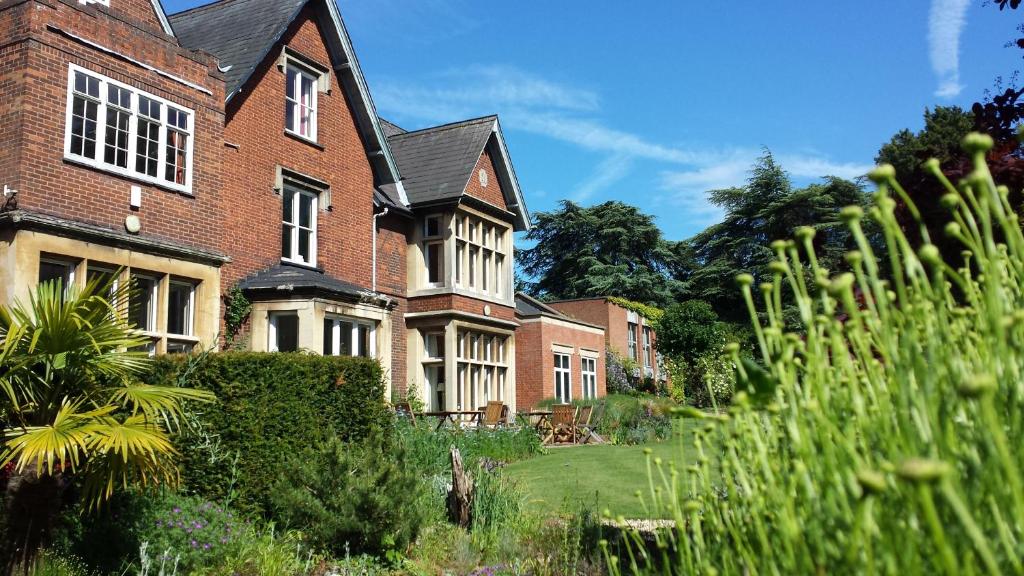 a large brick house with a garden in front of it at Benslow Music Historic Stay in Hitchin in Hitchin