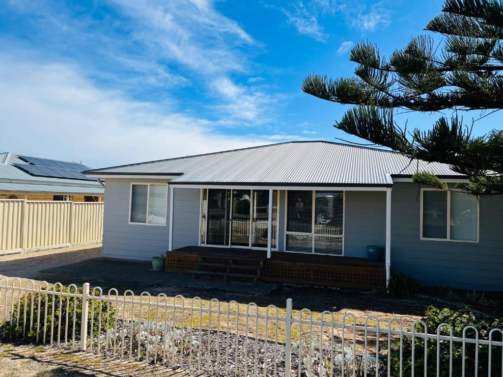 a white house with a fence in front of it at Elandra House - WiFi pet friendly outside in Robe