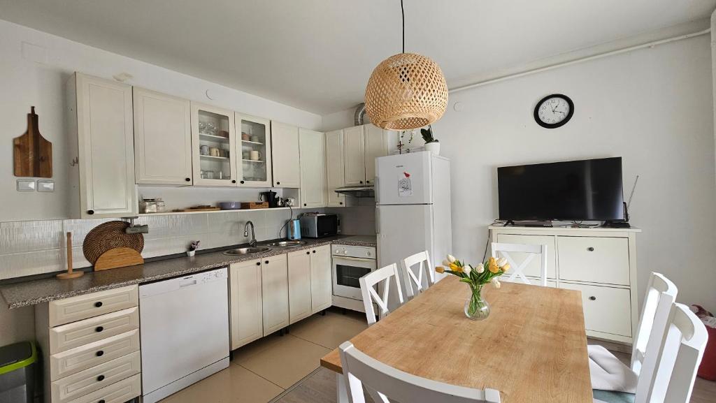 a kitchen with a table and a white refrigerator at St Anthony's House with Parking in Zagreb