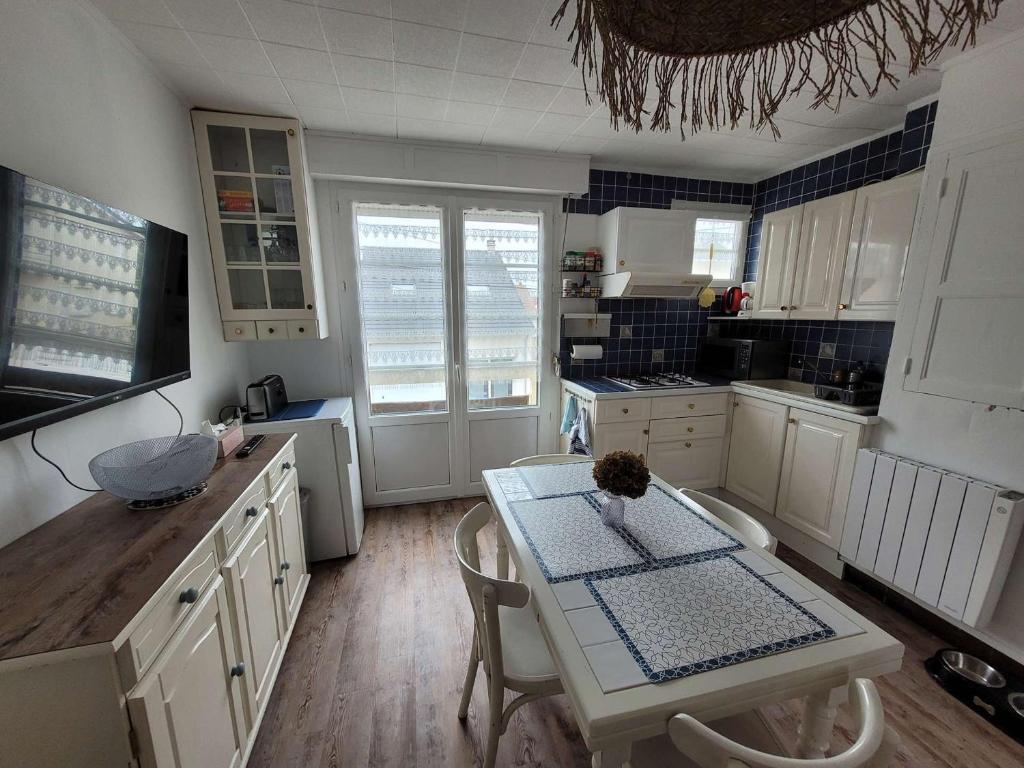- une cuisine avec une table, une table et des chaises dans l'établissement Appartement cosy 4 pers avec balcons à 2 min de la plage - FR-1-672-36, à Merlimont