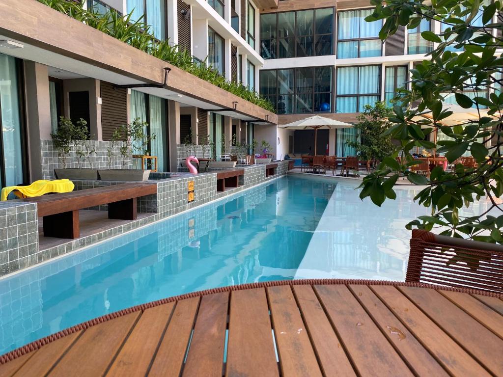 a swimming pool with a wooden deck and a building at Sunny Hall - Porto de Galinhas in Porto De Galinhas