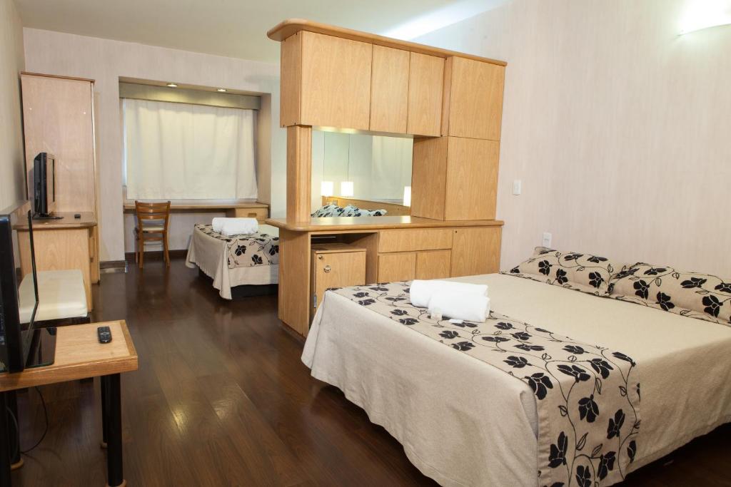 a hotel room with two beds and a television at Hathor Hotels Mendoza in Mendoza