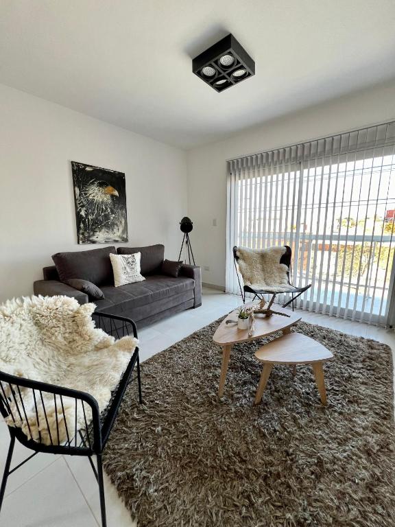 a living room with a couch and a table and chairs at AG Apartment in Trelew