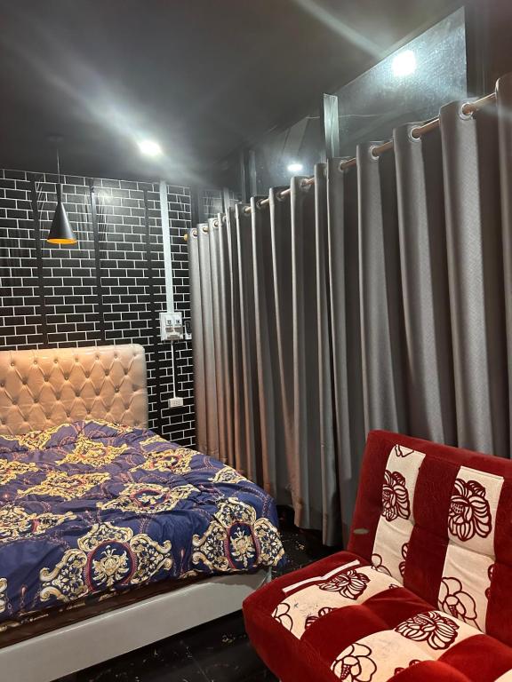 una camera da letto con un letto, una sedia e delle tende di Meenoy hotel Vientiane Laos 旅館 a Ban Doung