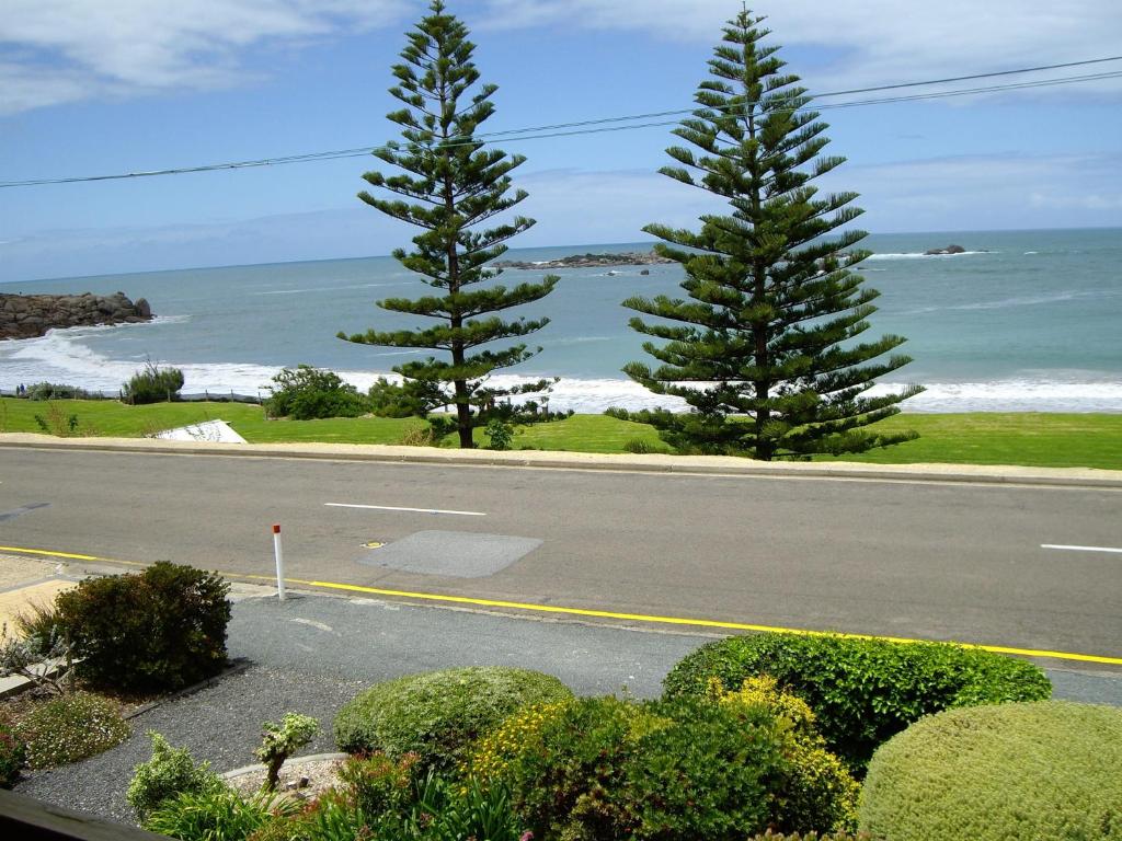 埃利奥特港Commodore 2 2-18 Basham Rd Port Elliot - Linen Included的一条空旷的道路，两棵松树和大海