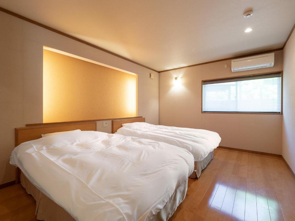 Postel nebo postele na pokoji v ubytování 天空の湯屋 山荘 華柚