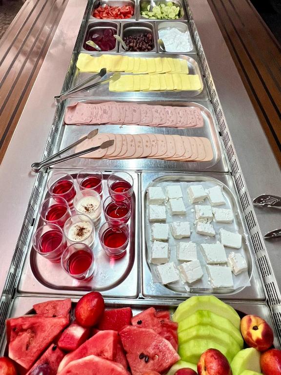 a buffet with several trays of different types of food at Karteros Hotel in Karteros