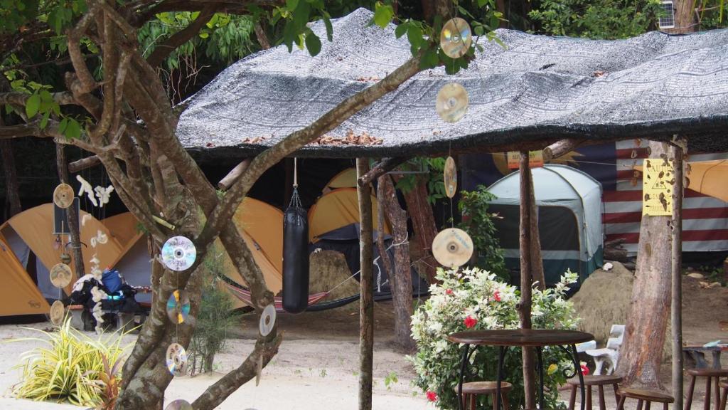a tent with a table and chairs and a tree at Redang Campstay in Redang Island