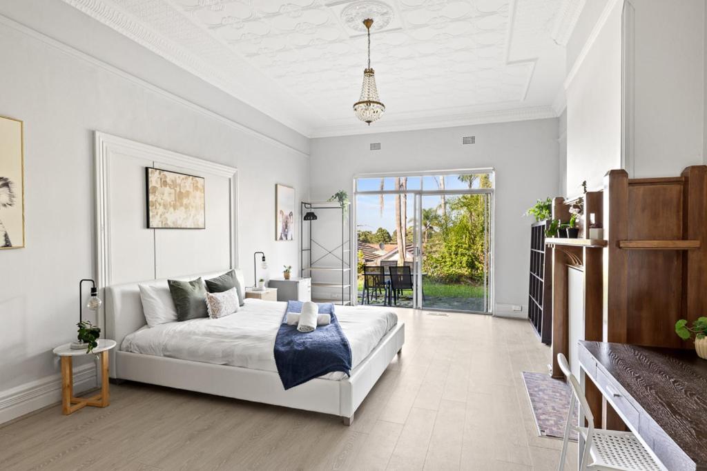 KillaraSpacious King Room - Nearby Stations & Stores - Shared Bathroom的白色卧室设有床和滑动玻璃门