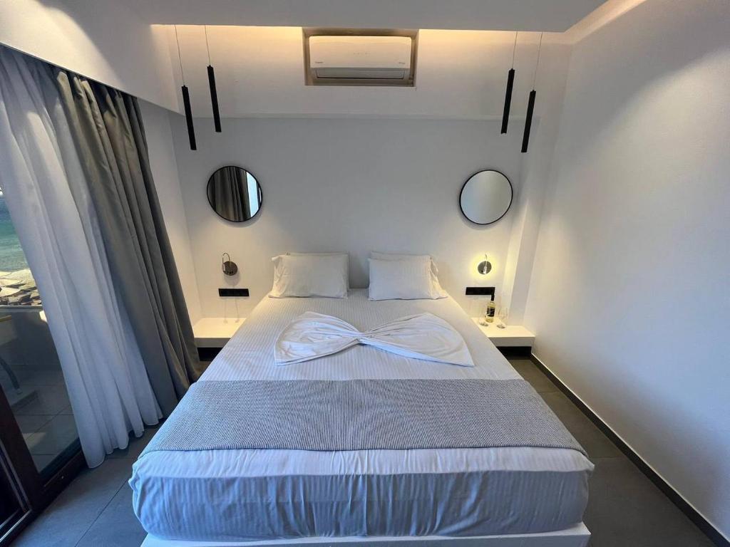 a bedroom with a bed with a bow tie on it at Blue Green Bay in Panormos Skopelos
