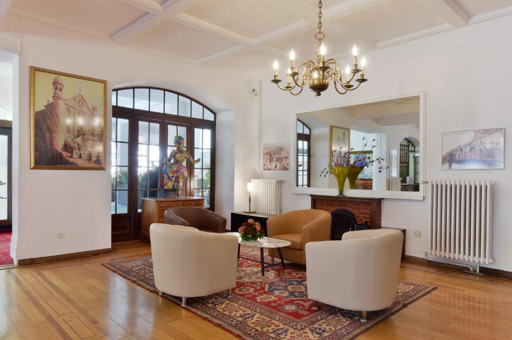 a living room with a chandelier and a table and chairs at J5 Hotels Helvetie & La Brasserie in Montreux
