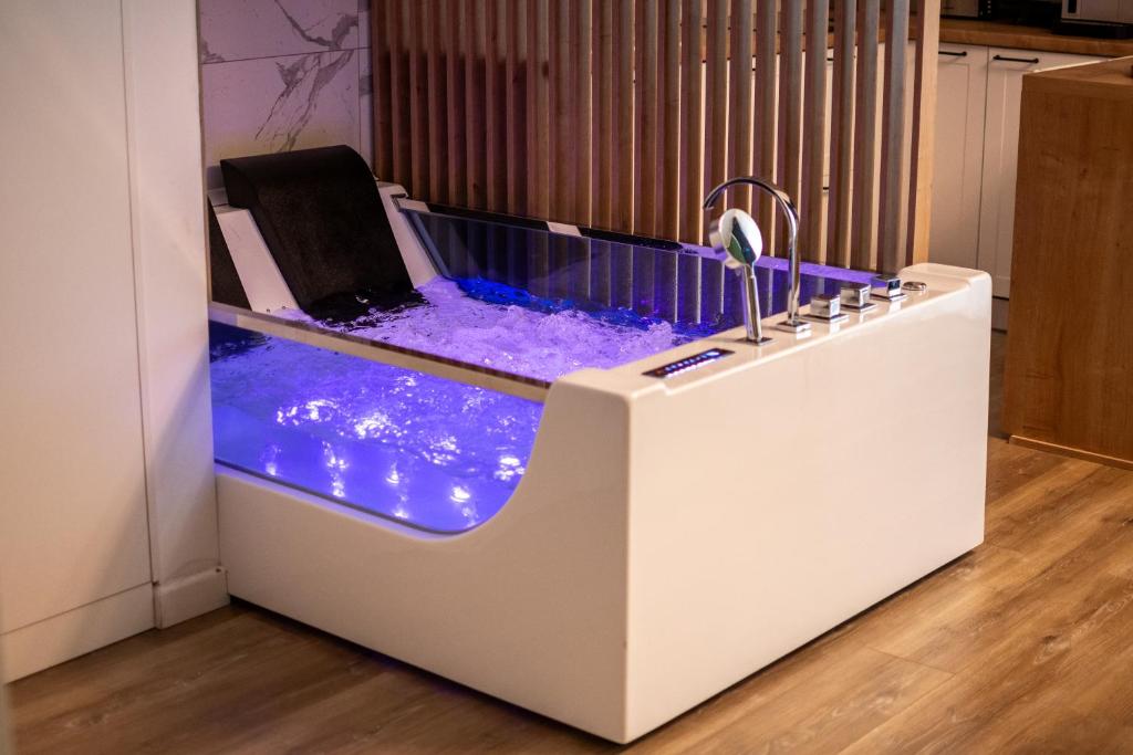 a jacuzzi tub in a kitchen with blue lighting at Jacuzzi Urban Heaven Studio in Sinaia