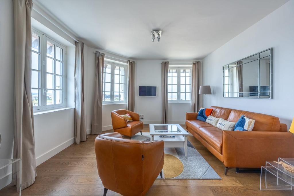 un salon avec un canapé et une chaise dans l'établissement Appartement Les Goélands - Welkeys, à Trouville-sur-Mer