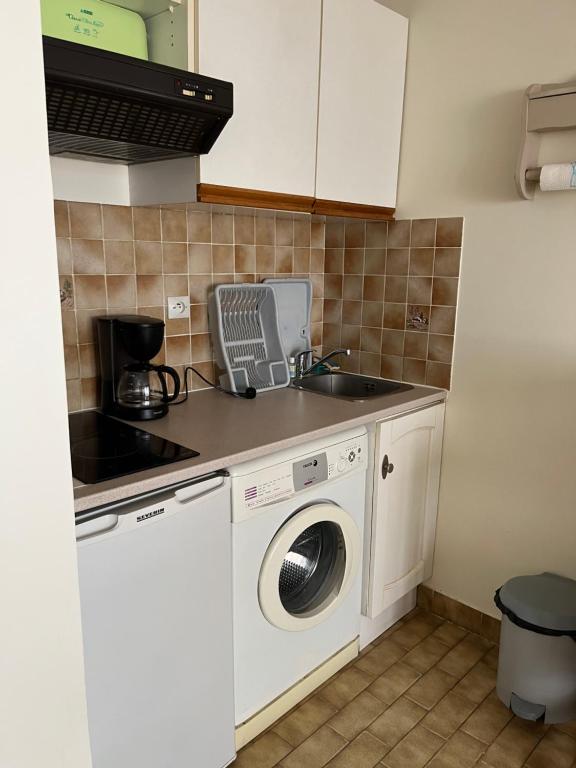 a kitchen with a washing machine and a sink at Studio Mer in Le Grau-du-Roi