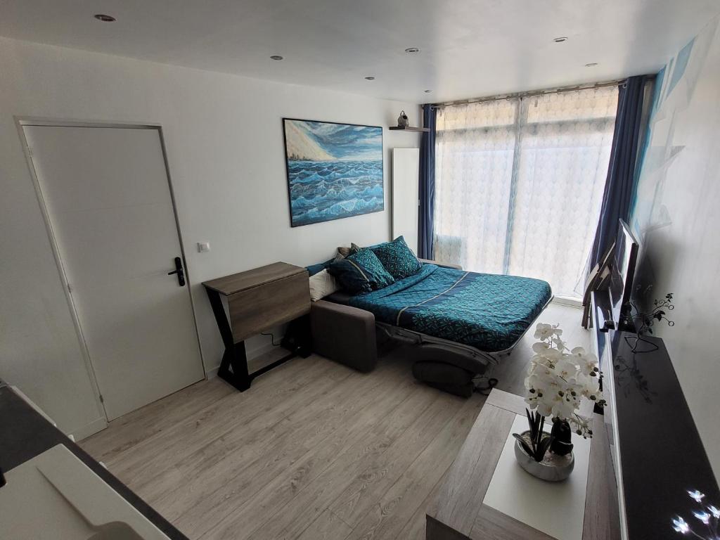 une chambre avec un lit, un bureau et une fenêtre dans l'établissement Studio F1 tout confort centre ville, à Beaumont-sur-Oise