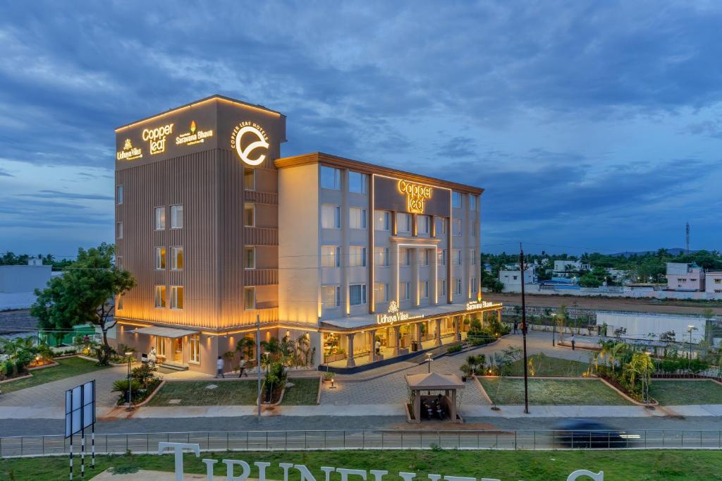 un edificio de hotel con un reloj encima en Copper Leaf Hotels, Tirunelveli, en Tirunelveli