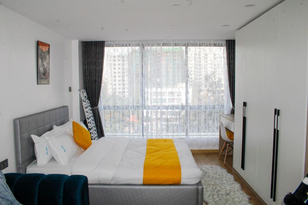 a bedroom with a bed and a large window at Executive Studio Apartment in Kilimani, Nairobi in Nairobi